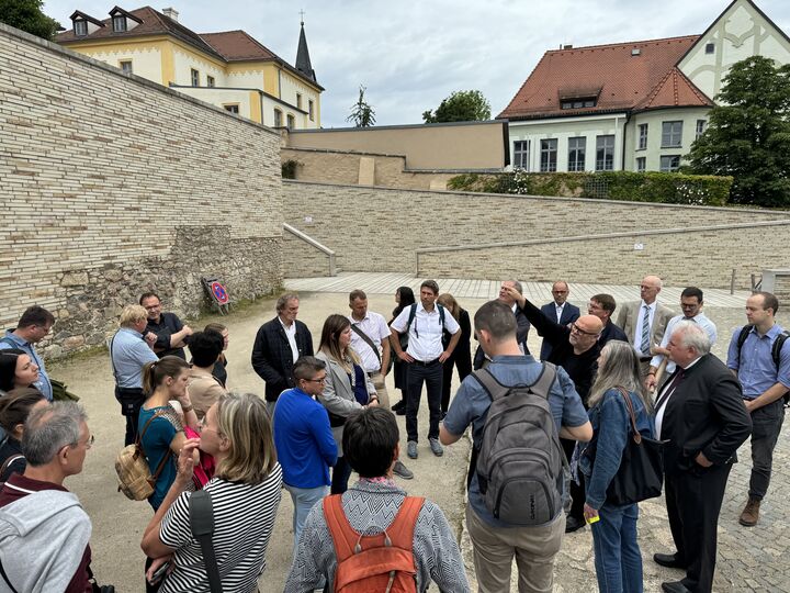 Architekt Peter Brückner erklärt den Teilnehmern der Exkursion die Schritte auf dem Weg zum neuen Lernstandort. Foto: Regierung der Oberpfalz/Schmied